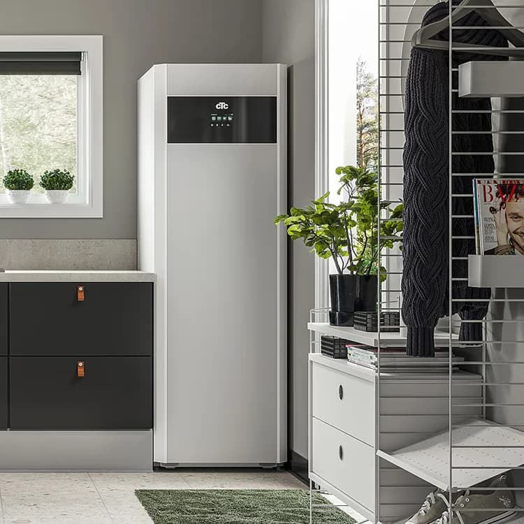 Modern tvättstuga med vit apparat, krukväxt, förvaringshyllor och fönster. En VVS-inspirerad design integreras sömlöst med den eleganta funktionaliteten hos ett värmepumpsystem, vilket förbättrar både effektivitet och stil.